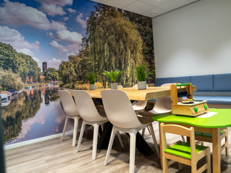 Wachtkamer huisartsenpraktijk met foto van Haarlem op de muur.